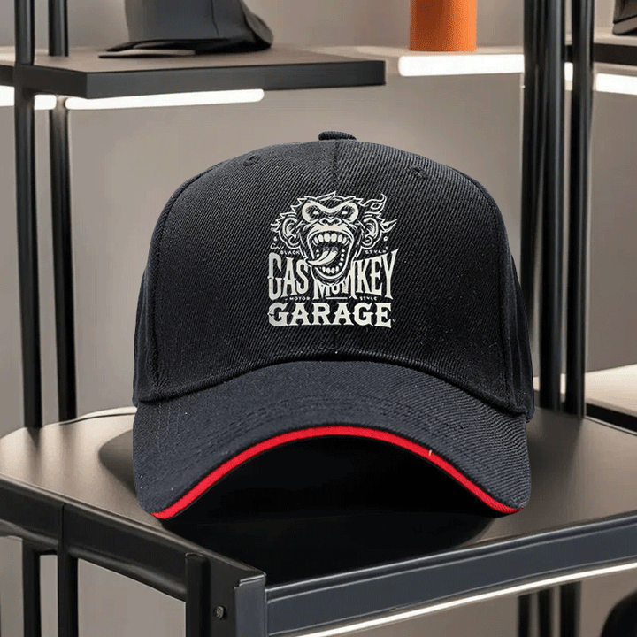 Una gorra de béisbol impresa unisex de Gas Monkey Garage, con una visera de estilo sándwich y diseño ajustable. Esta gorra de padre ligera muestra un patrón de mono de dibujos animados, una visera curva y un logotipo blanco y negro, lo que la convierte en
