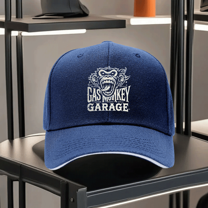 Una gorra de béisbol impresa unisex de Gas Monkey Garage, con una visera de estilo sándwich y diseño ajustable. Esta gorra de padre ligera muestra un patrón de mono de dibujos animados, una visera curva y un logotipo blanco y negro, lo que la convierte en