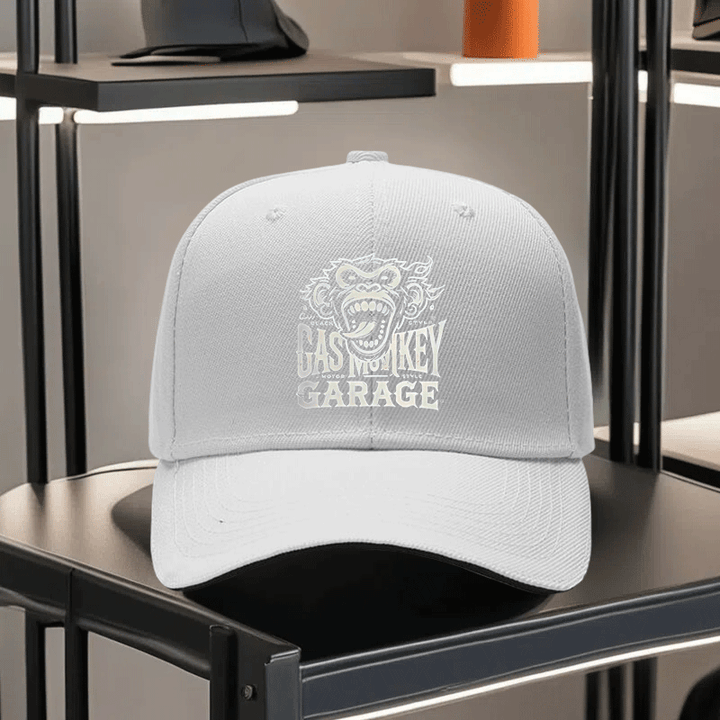 Una gorra de béisbol impresa unisex de Gas Monkey Garage, con una visera de estilo sándwich y diseño ajustable. Esta gorra de padre ligera muestra un patrón de mono de dibujos animados, una visera curva y un logotipo blanco y negro, lo que la convierte en