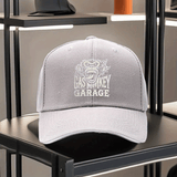 Una gorra de béisbol impresa unisex de Gas Monkey Garage, con una visera de estilo sándwich y diseño ajustable. Esta gorra de padre ligera muestra un patrón de mono de dibujos animados, una visera curva y un logotipo blanco y negro, lo que la convierte en